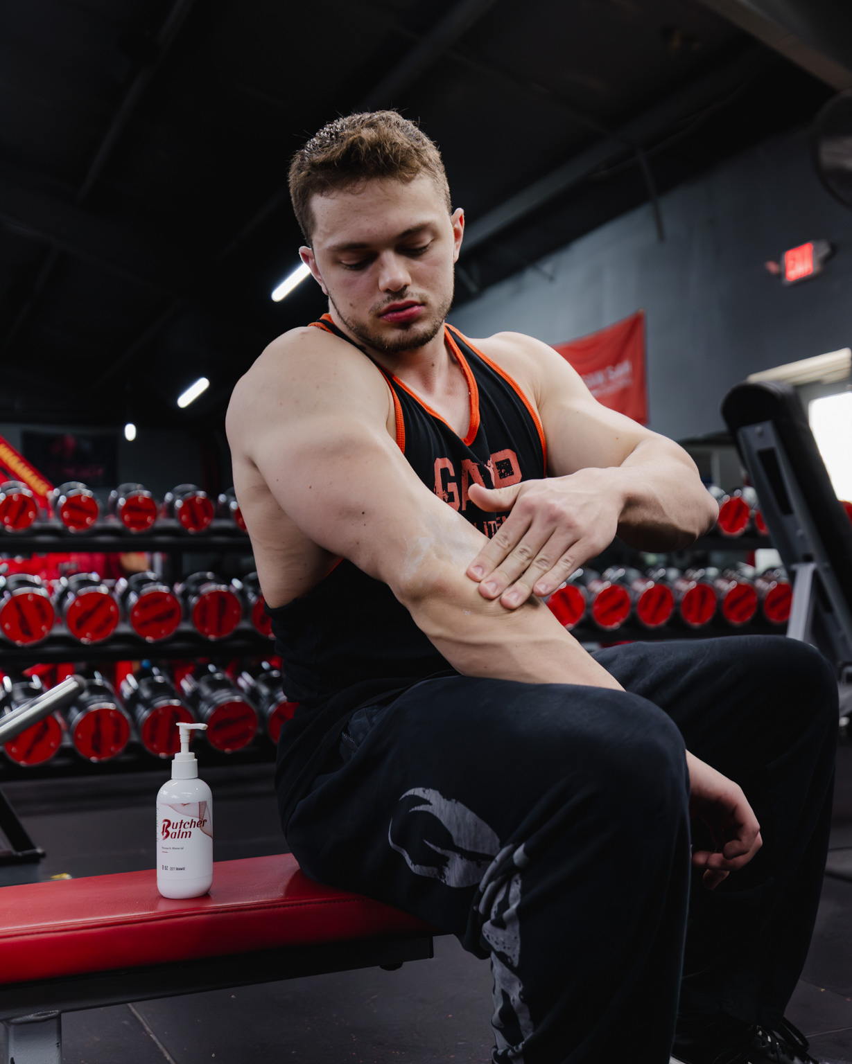 Applying Butcher Balm to forearm at the gym